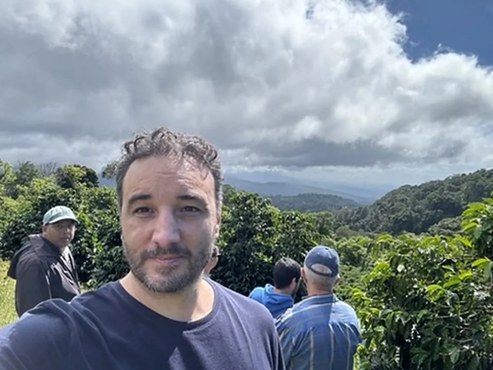 Thomas Bertrand sur un versant caféier de Boquete, les nuages accrochés aux montagnes derrière lui