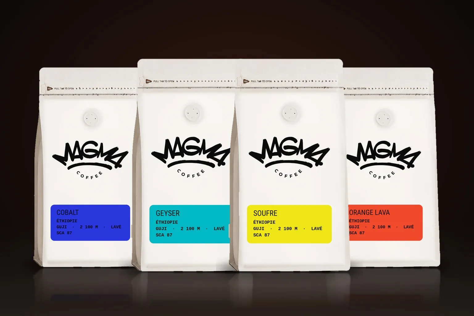 Les quatre sachets blancs Magma Coffee 1 kg, cartouches cobalt, geyser, soufre et orange lava — Brésil Muriqui, Éthiopie Ghost, Panama Luna et Chine Red River