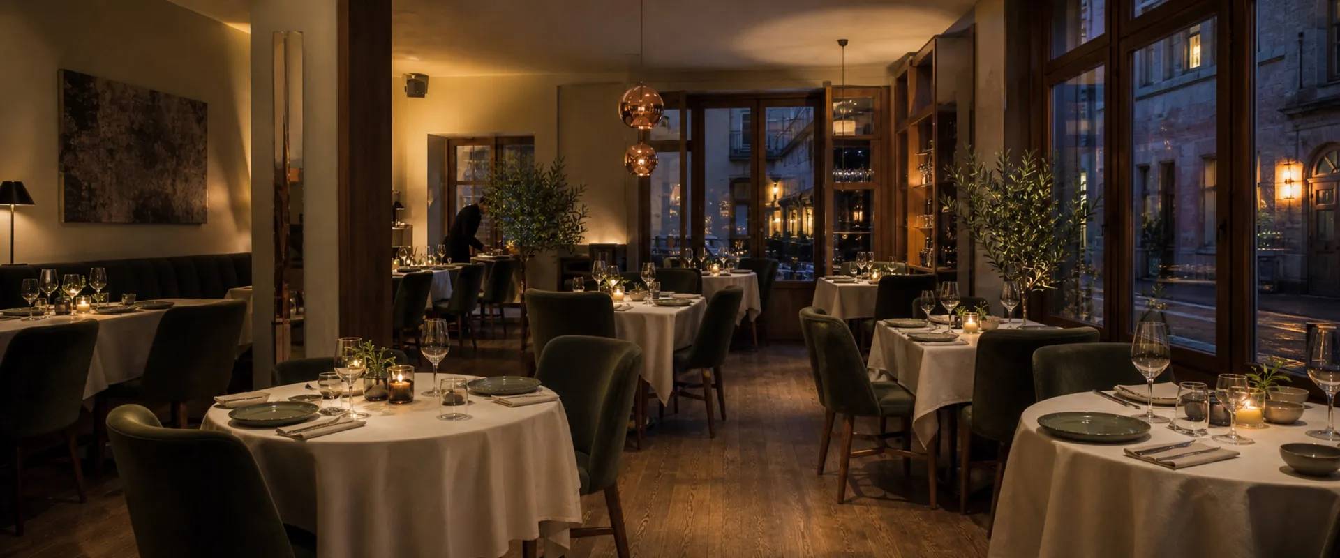 Salle de restaurant gastronomique contemporaine, tables dress&eacute;es, lumi&egrave;re basse